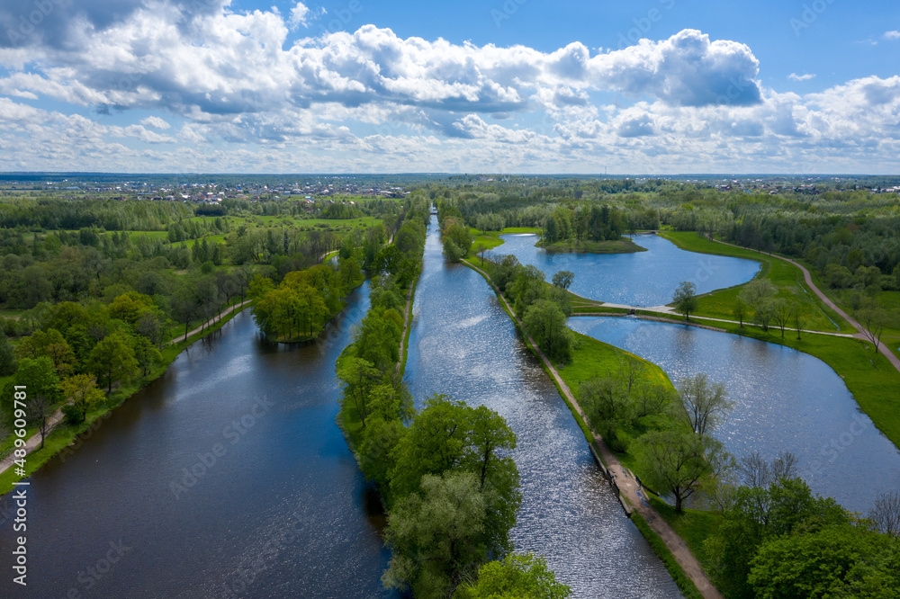 Fototapeta premium A panoramic view from a height of the ponds and the Landscape Park in Peterhof, the meadow garden, walking paths, the destroyed pavilion.