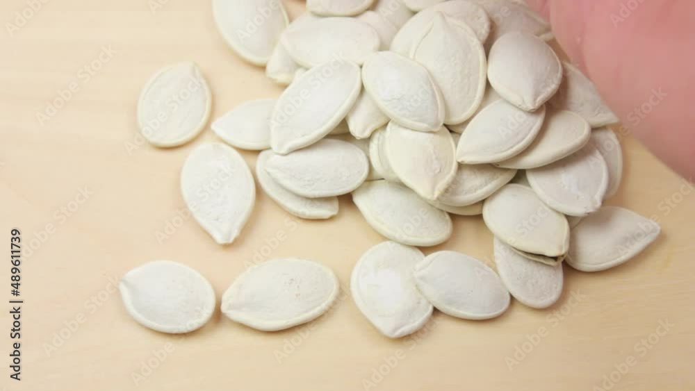 The Pumpkin seeds in the palm of a close-up. Natural pumpkin seeds. The Pumpkin seeds in the palm of a close-up. Natural pumpkin seeds.
