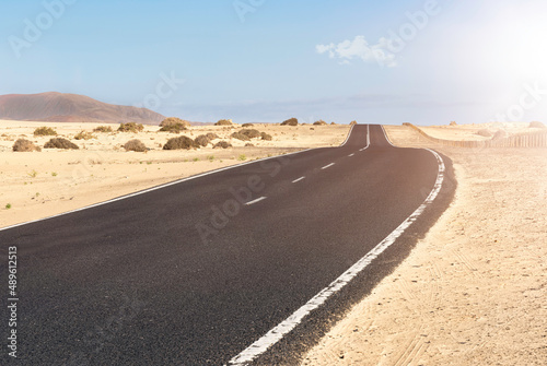 desert road that crosses the dunes of the Corralejo dune natural park in Fuerteventura in Spain.