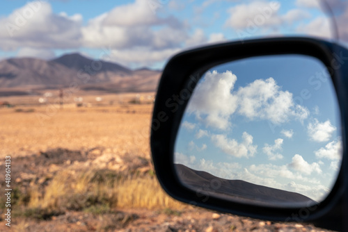 reflection of clouds in the rearview mirror of a car - selective focus.