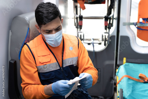 photo of a young paramedic reading an electrocardiogram sitting in the ambulance. stock photography