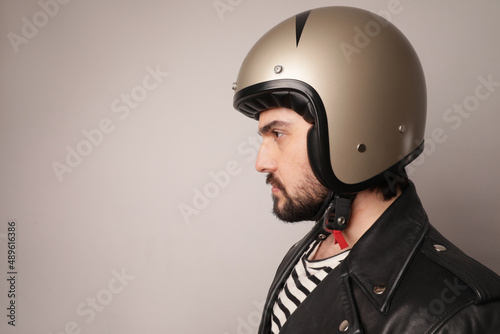 Close-up portrait of bearded biker man in leather jacket and motorcycle helmet. © face_reader_img