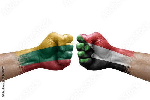 Two hands punch to each others on white background. Country flags painted fists, conflict crisis concept between lithuania and sudan