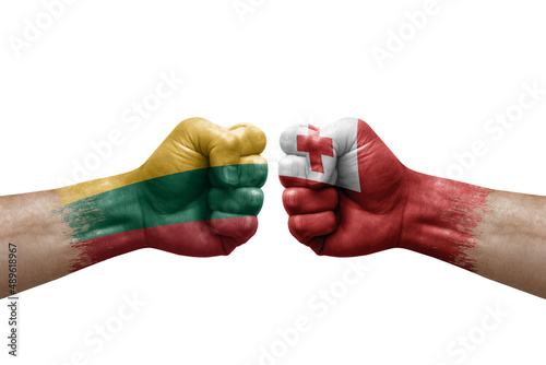 Two hands punch to each others on white background. Country flags painted fists, conflict crisis concept between lithuania and tonga