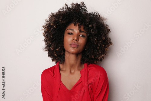 Young beautiful woman with curly brown hair posing on white background. 
