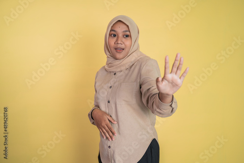 Asian woman in hijab standing with hand gesture refusing offer © Odua Images