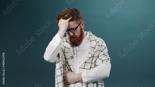 A bearded man has a cold. He sneezes and coughs photo