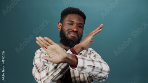 A young black man is gesturing and looking at the camera