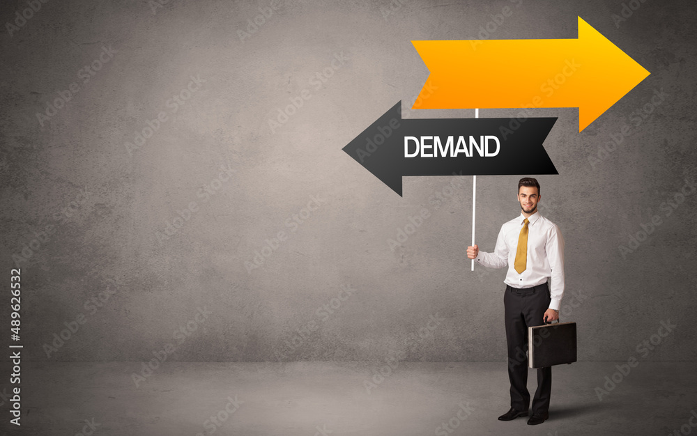 Young business person in casual holding road sign Young business person in casual holding road sign