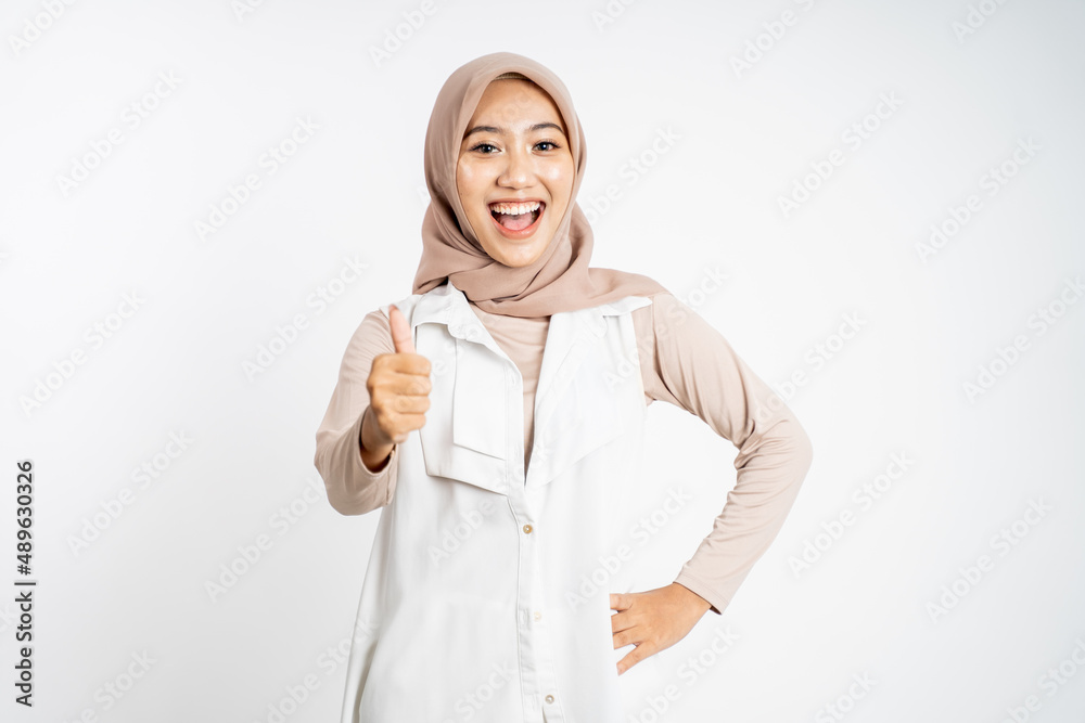 woman in hijab smiling with thumbs up while standing woman in hijab smiling with thumbs up while standing