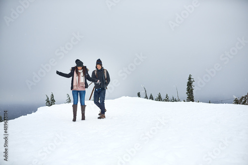 We love being out in the snow. Shot of a happy young couple enjoying themselves while being out in the snow.