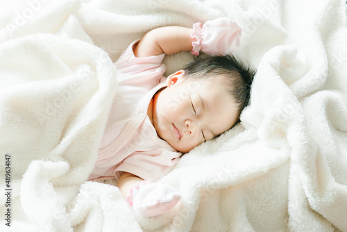 Portrait of Asian newborn or baby girl sleeping on bed New born kid concept.