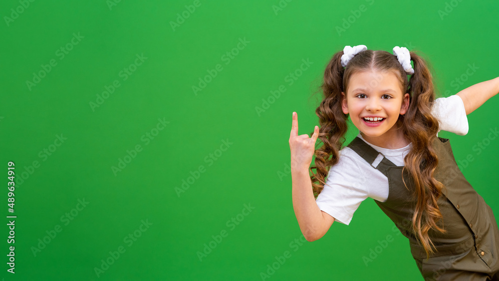 A little girl looks around the corner and smiles. A child on an isolated background and copying space.