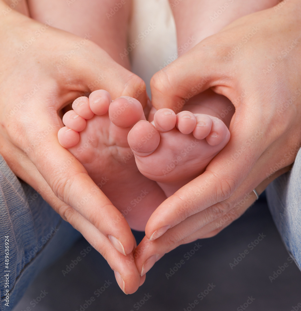 Loving the little things. Cropped shot of a mothers hands making a heart shape around her babys feet.