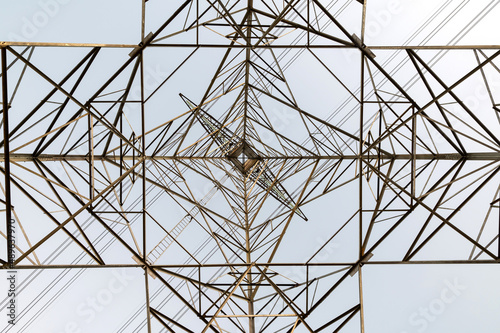 Abstract structure high voltage transmission tower on sky background.