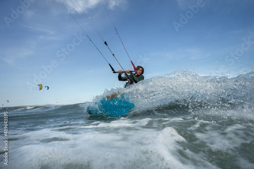 A kite surfer rides the waves.