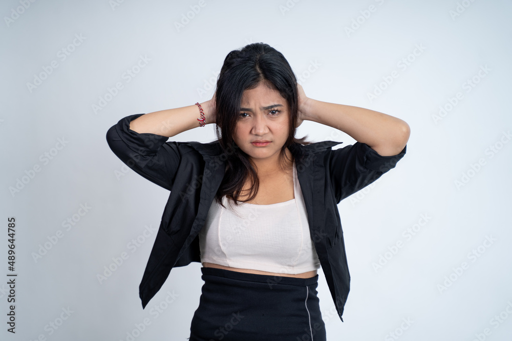 Young woman holding head while confused by situation Young woman holding head while confused by situation