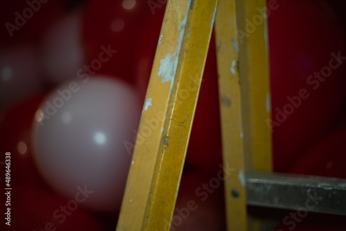 red and white balloon arrangement near a yellow ladder