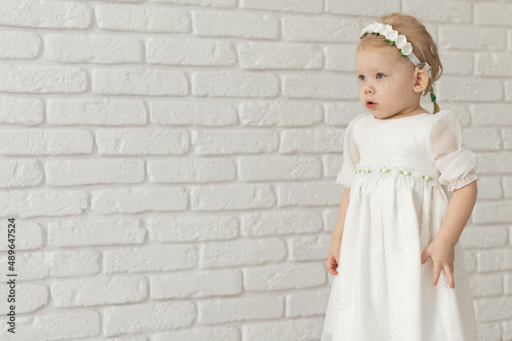 Baby child with hearing aids and cochlear implants on white brick wall with copy space and place for advertising . Deaf and health concept Baby child with hearing aids and cochlear implants on white brick wall with copy space and place for advertising . Deaf and health concept