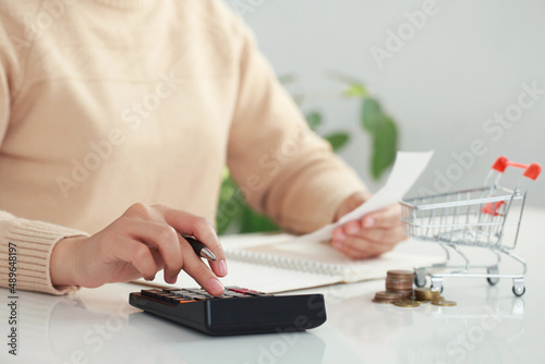  Women calculate food money with pen, paper, and calculator at home. Budget of disadvantaged and low-income families.high daily expenses. Debt, inflation and economic crisis Concept. photo