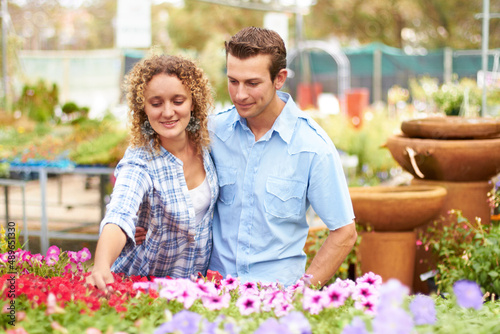 Our gardens going to look beautiful. A happy couple choosing flowers in a nursary.