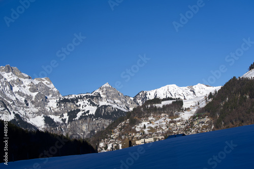 Aerial view of mountain panorama at the Swiss Alps seen from ski resort Engelberg, focus on background. Photo taken February 9th, 2022, Engelberg, Switzerland. © Michael Derrer Fuchs