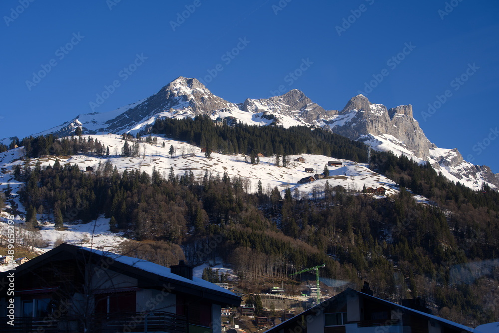 Aerial view of mountain panorama at the Swiss Alps seen from ski resort Engelberg, focus on background. Photo taken February 9th, 2022, Engelberg, Switzerland.