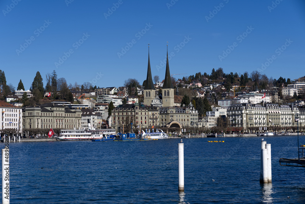 Roman catholic Court Church at City of Luzern on a sunny winter day with lake Luzern in the foreground, focus on background. Photo taken February 9th, 2022, Lucerne, Switzerland.