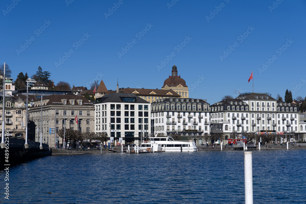 Cityscape of Luzern with lake Lucerne in the foreground on a sunny winter day. Photo taken February 9th, 2022, Lucerne, Switzerland.