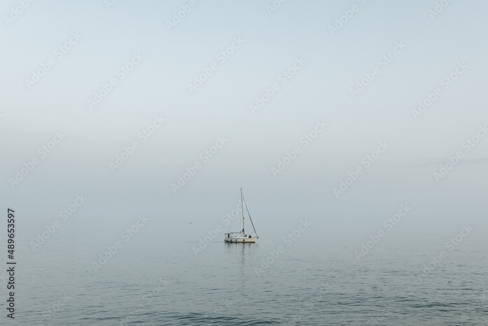 Lonely sailboat out on the ocean off the Mediterranean Sea in Sitges, Spain.