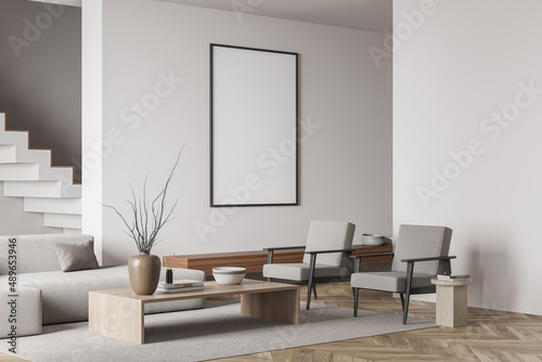 Beige living room interior with empty white framed mockup poster on wall, sofa, stairs, armchair Hardwood floor. Concept of minimalist design. Creative idea. Mock up. 3d rendering