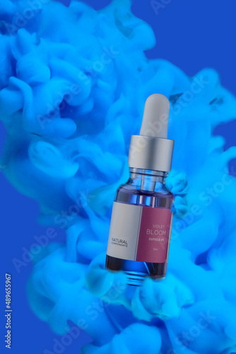 A bottle of cosmetic liquid on a blue background with clouds.