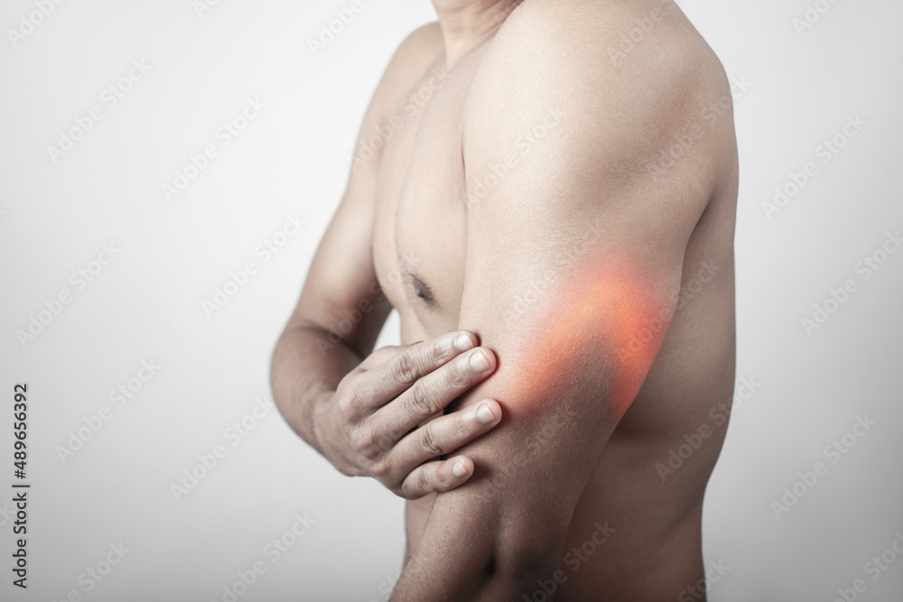 fitness man touching his inflamed triceps zone, body pain concept fitness man touching his inflamed triceps zone, body pain concept