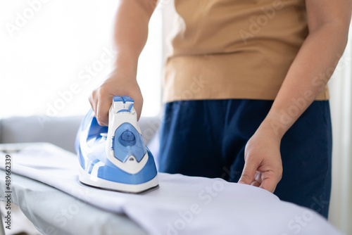 Female ironing on shirt housework at home