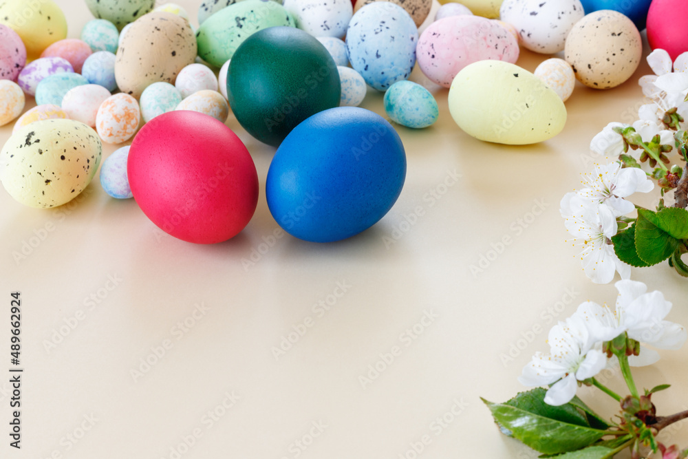 Beautiful Easter card with colorful eggs and cherry branches on paper beige background.
