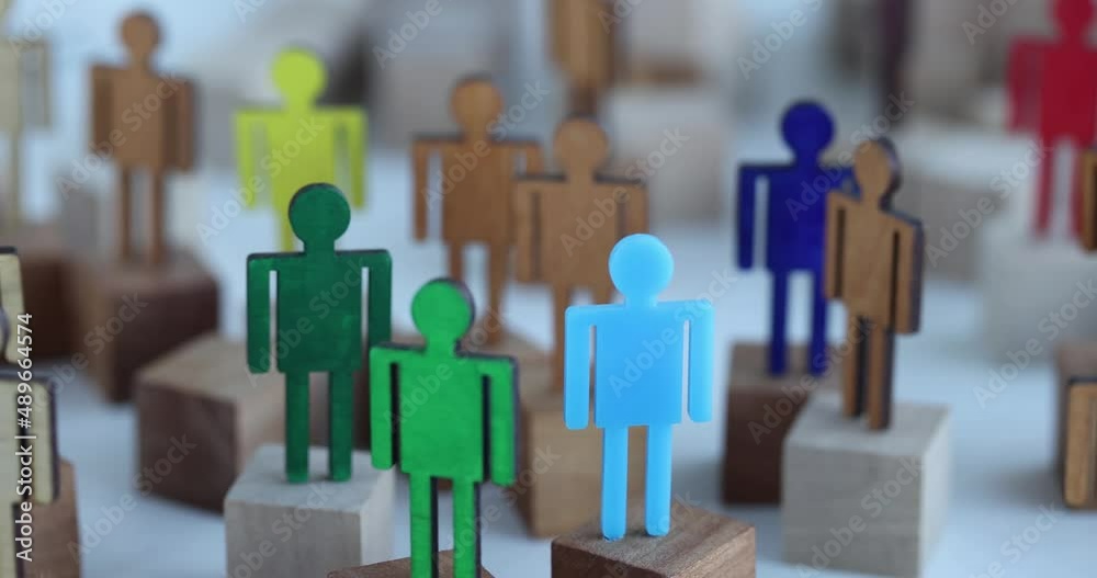 Multi-colored wooden figurines in crowd of identical ones closeup Multi-colored wooden figurines in crowd of identical ones closeup