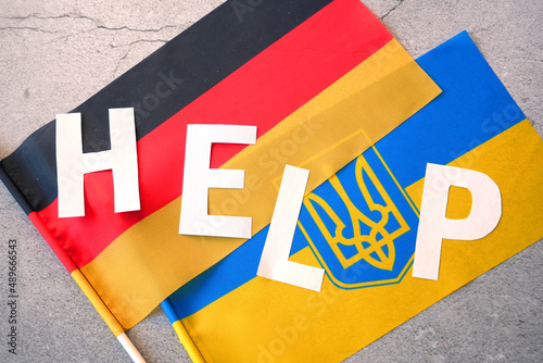 Ukrainian and Germany flag pair and word help, ukraine and germany politics economy relationship concept, help in war between Ukraine and Russia, february 2022, top view photo