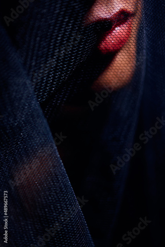 Red lips under dark veil