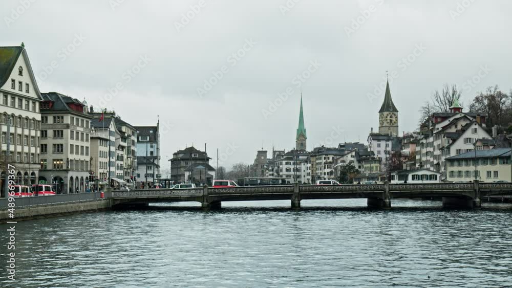 Beautiful day with Birds flying over the Limmat River in Zürich, Switzerland. Church of St. Peter, Swiss National Museum and other historical building in the city center of Zurich. Beautiful day with Birds flying over the Limmat River in Zürich, Switzerland. Church of St. Peter, Swiss National Museum and other historical building in the city center of Zurich.