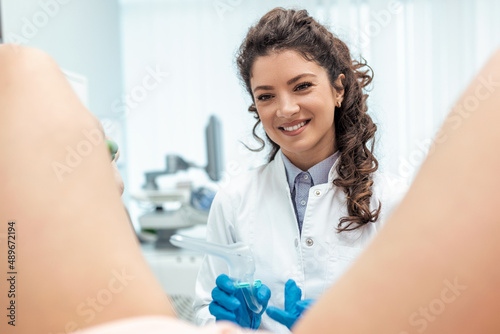 Treatment of cervical disease. Female gynecologist woman patient in gynecological chair during check up with gynecological speculum. Gynecologist examines a woman. Diagnostic, medical service. photo