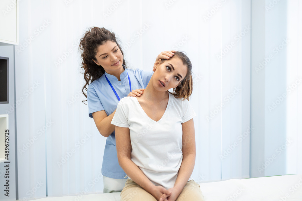 Female physiotherapist or a chiropractor adjusting patients neck. Physiotherapy, rehabilitation concept. White background front view with copy space Female physiotherapist or a chiropractor adjusting patients neck. Physiotherapy, rehabilitation concept. White background front view with copy space
