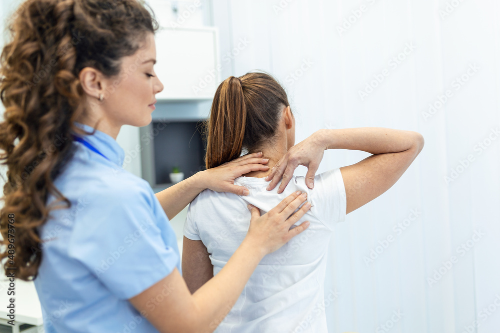Obraz premium Physiotherapist doing healing treatment on womans back. Back pain patient, treatment, medical doctor, massage therapist.office syndrome
