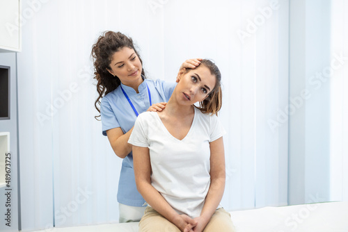 Female physiotherapist or a chiropractor adjusting patients neck. Physiotherapy, rehabilitation concept. White background front view with copy space photo