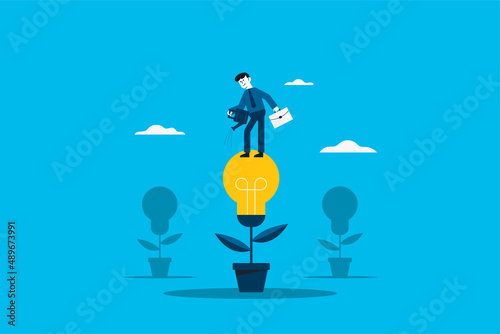 Creating ideas business creative idea concept . Business man with pot watering light bulb tree.