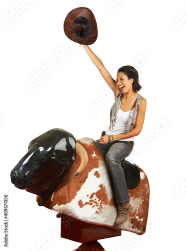 Yeehaw. Studio shot of a beautiful young woman riding a mechanical bull against a white background.