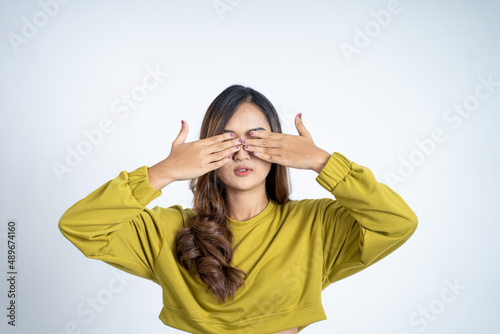 Young asian woman closing eyes with both palms