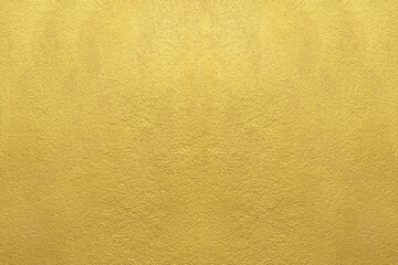 Gold wall texture background. Yellow shiny gold paint on concrete wall surface