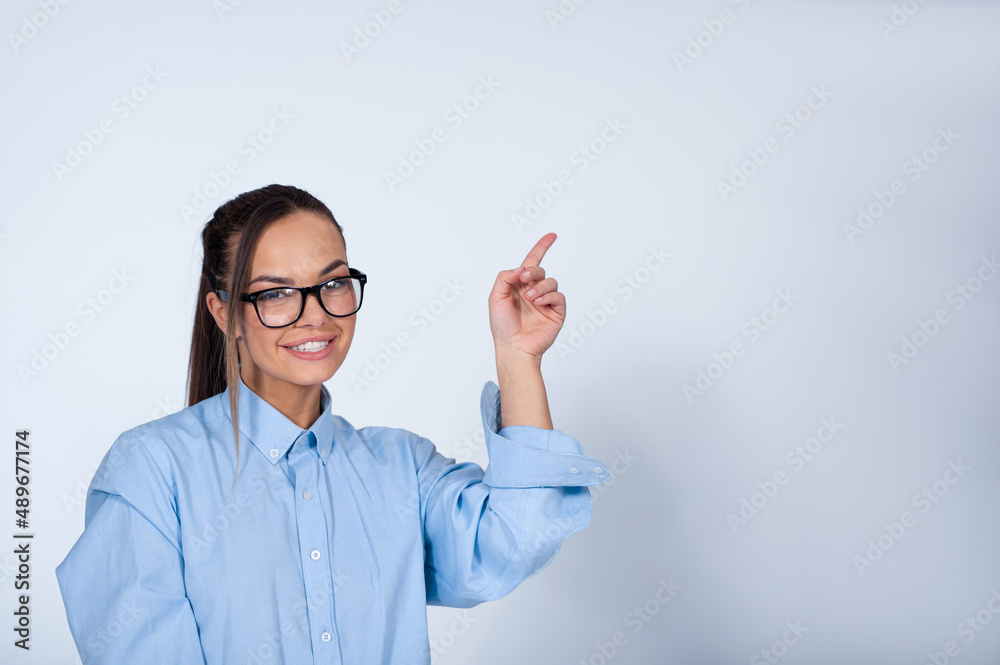 Young woman pointing up with finger and smiling Young woman pointing up with finger and smiling