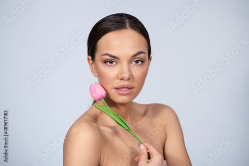 Beautiful young woman holding tulip flower