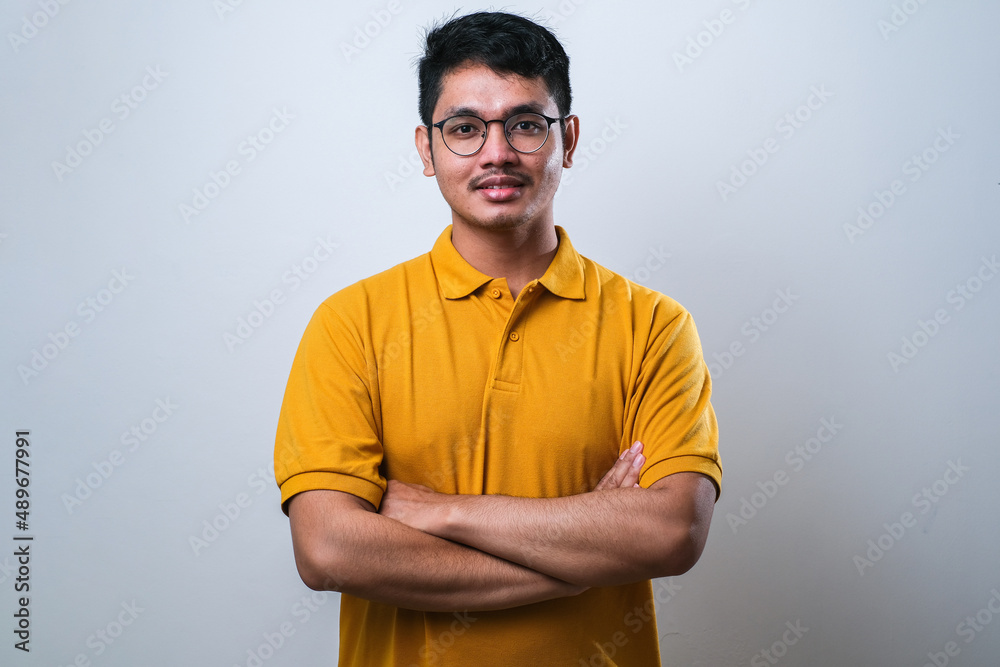 Portrait of happy asian young man looking to camera with crossed arms Portrait of happy asian young man looking to camera with crossed arms
